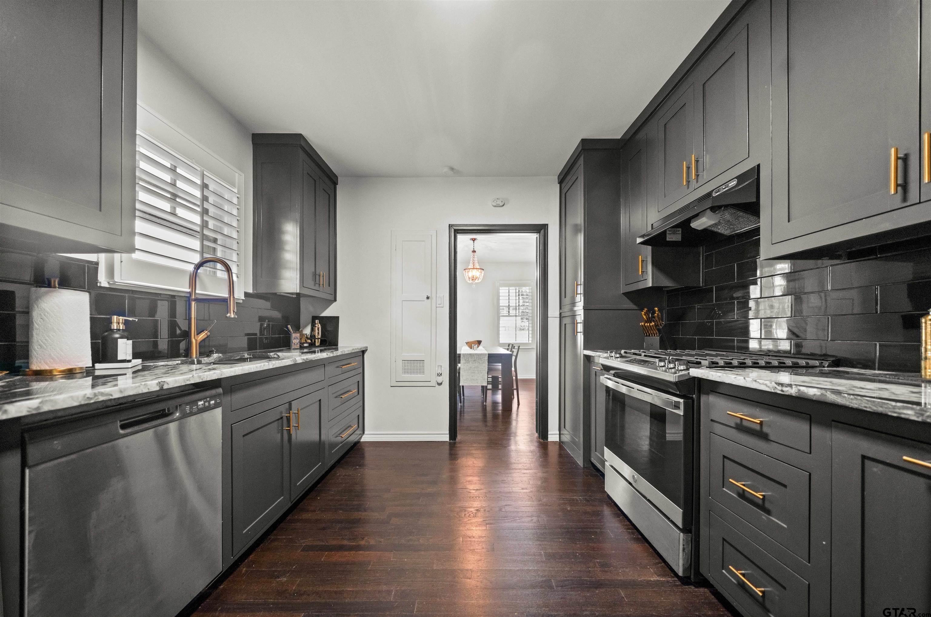 400 Lindsey Lane Tyler, TX 75701 - Photo 10 of 25 a large kitchen with stainless steel appliances granite countertop a stove top oven a sink dishwasher and a refrigerator with wooden floor