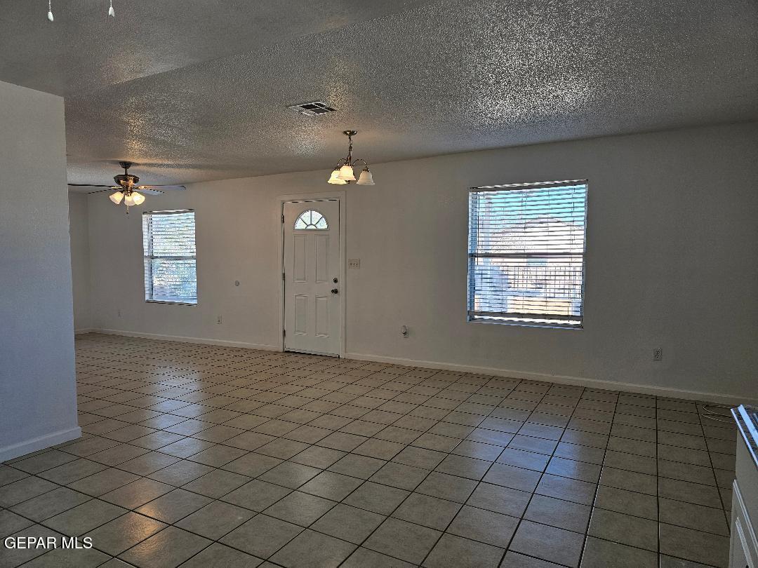 401 South 5th Street Anthony, TX 79821 - Photo 5 of 26 an empty room with kitchen view and windows