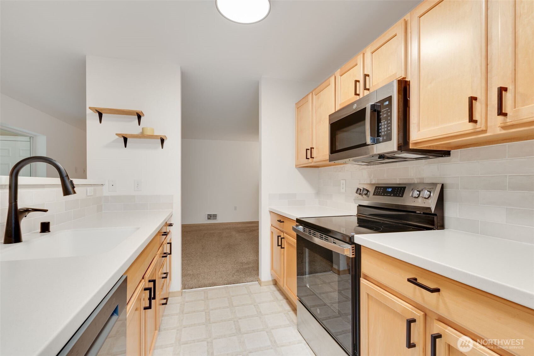 805 Harrington Place Southeast, Unit 3143 Renton, WA 98058 - Photo 4 of 25 a kitchen with stainless steel appliances a stove microwave and sink