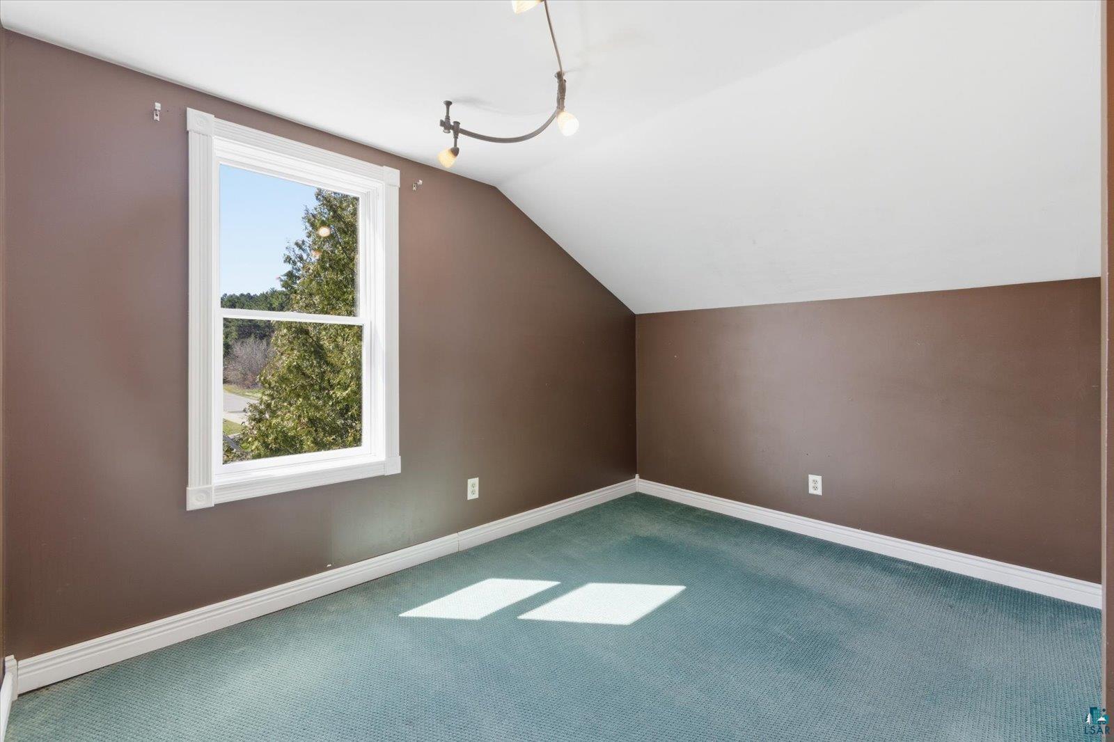 50 Main Street Soudan, MN 55782 - Photo 19 of 31 Room featuring a single window, a sloped ceiling, and blue carpeting