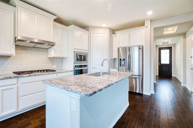 a kitchen with a refrigerator and a stove top oven