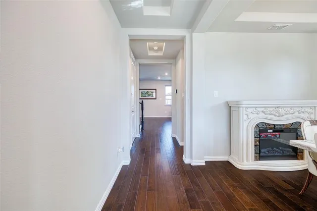 a view of a hallway with wooden floor and a fireplace