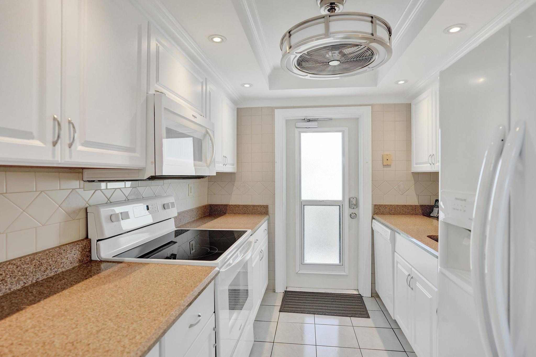 505 North Riverside Drive, Unit 7 Pompano Beach, FL 33062 - Photo 9 of 43 a kitchen with a sink and a refrigerator
