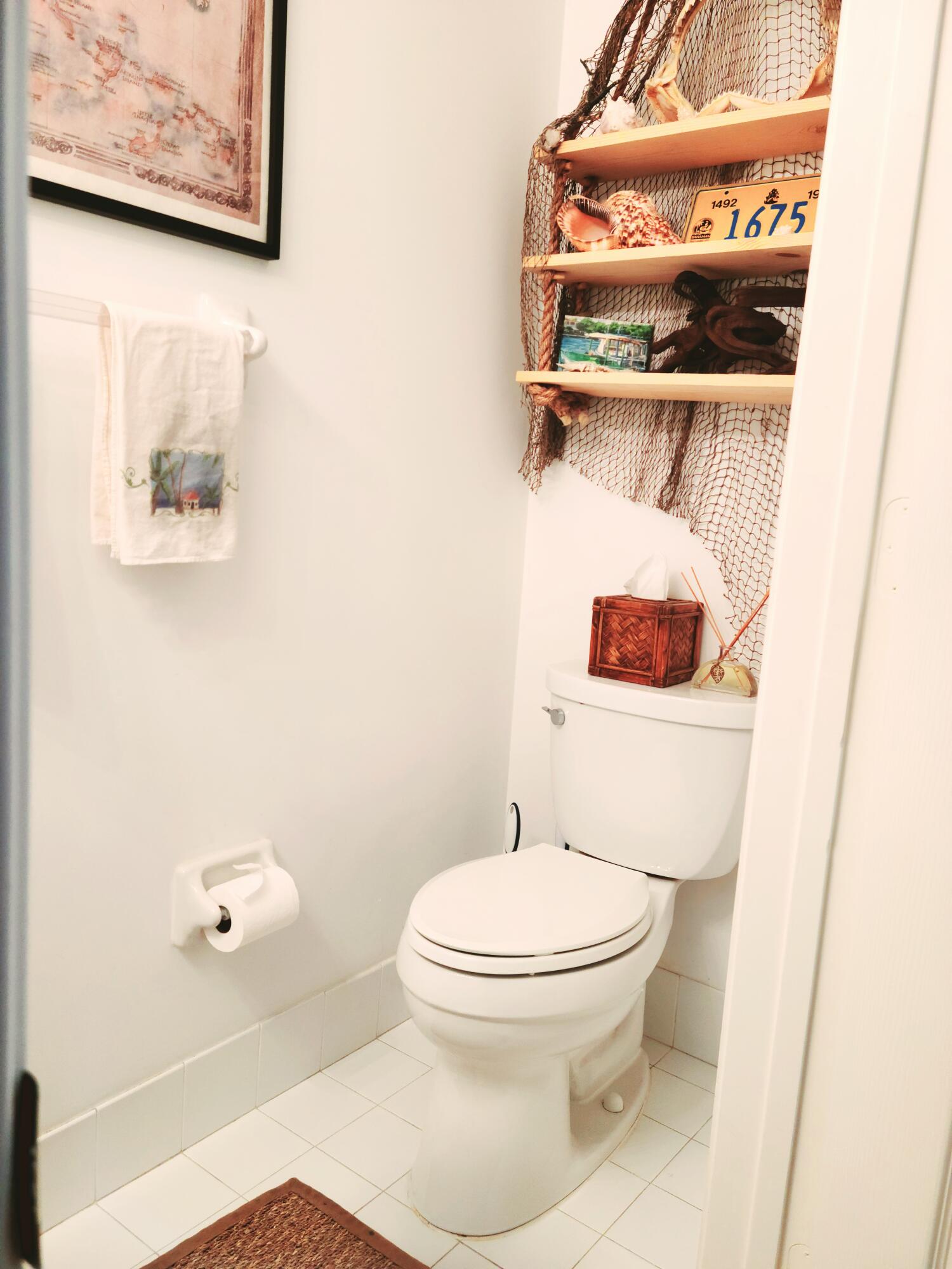 5121 Sabal Gardens Lane, Unit 2 Boca Raton, FL 33487 - Photo 11 of 25 a white toilet sitting next to a bathroom sink and a mirror
