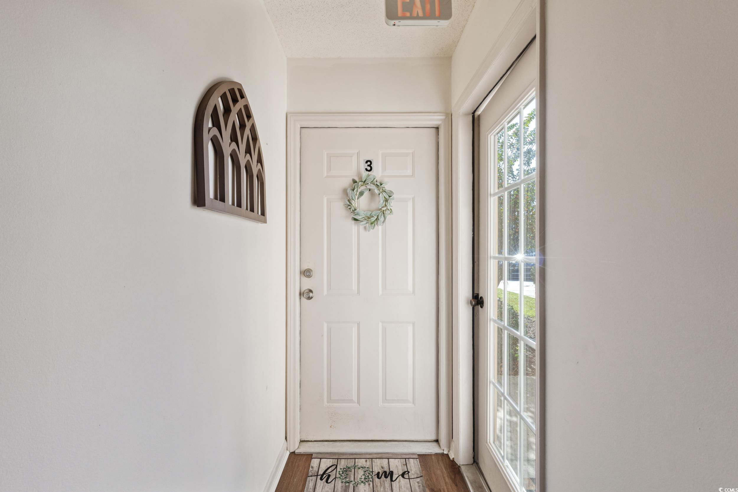 4242 Pinehurst Circle, Unit N3 Little River, SC 29566 - Photo 5 of 30 Doorway with wood finished floors and a textured ceiling