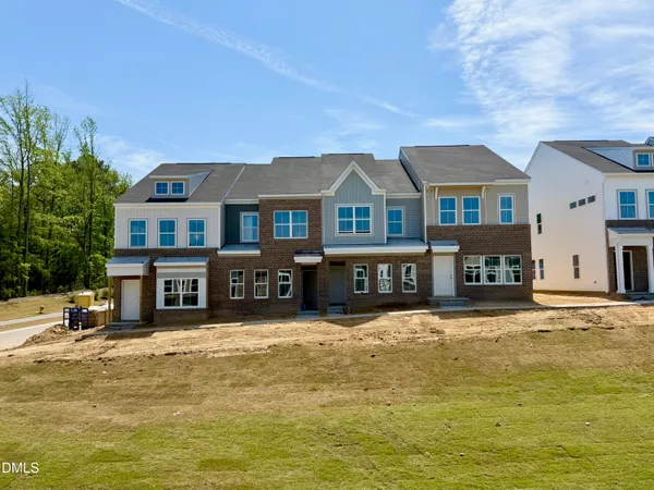a front view of a building with large pool and lawn chairs
