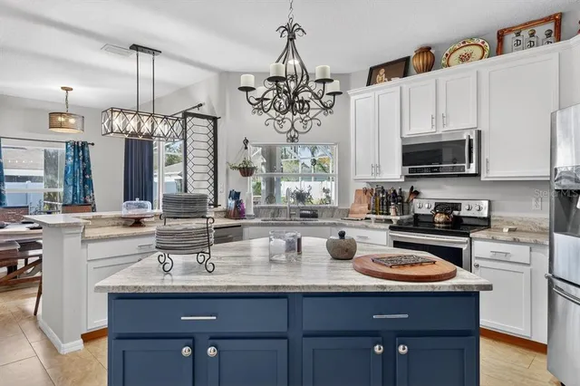 a kitchen with kitchen island granite countertop a sink cabinets and window