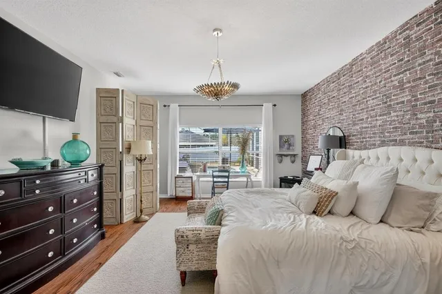 a bedroom with a bed and a flat tv screen on dresser