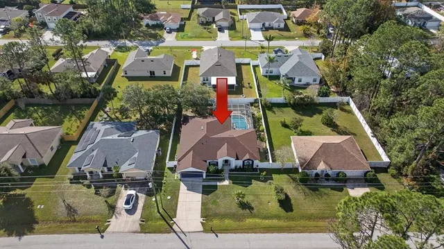 an aerial view of residential houses with outdoor space and trees