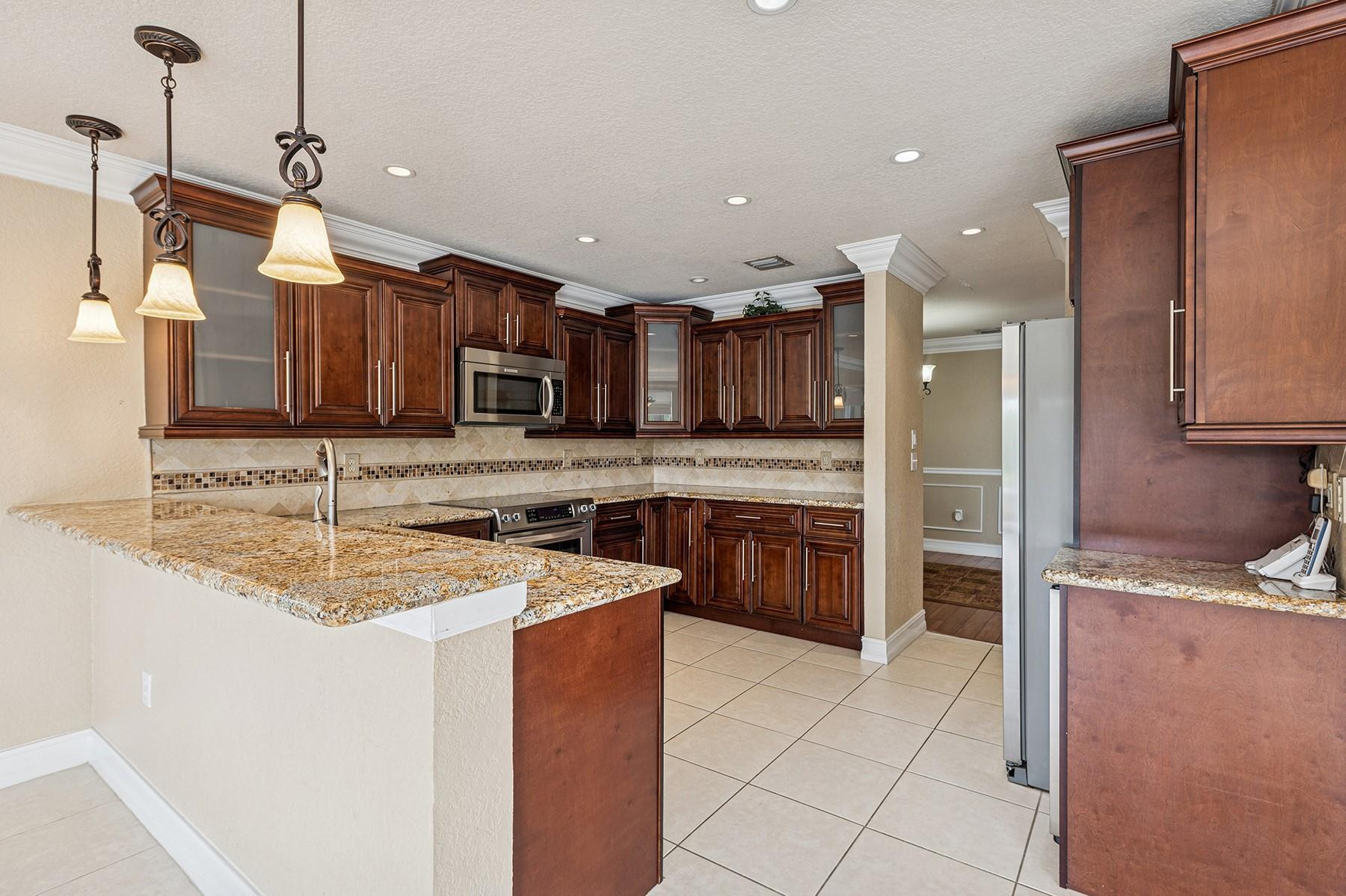 2755 Southwest 165th Avenue Miramar, FL 33027 - Photo 5 of 18 a kitchen with stainless steel appliances granite countertop a sink stove and refrigerator