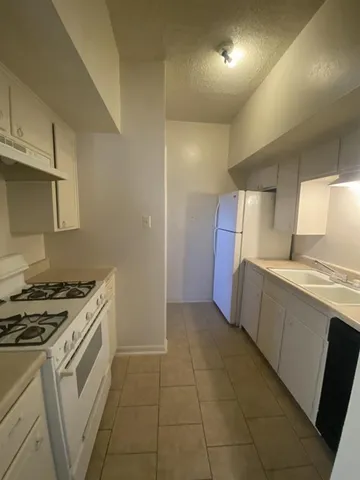 a kitchen with a stove top oven and cabinets