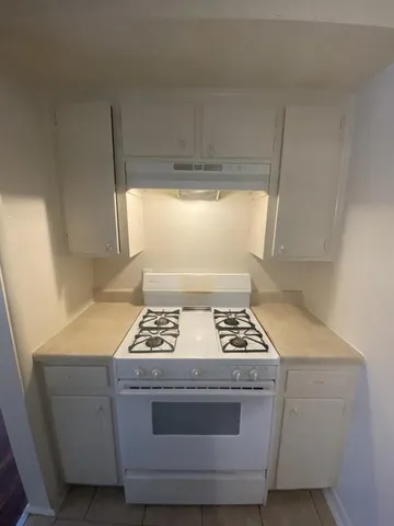 a stove top oven sitting inside of a kitchen
