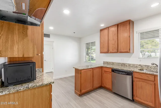 a kitchen with stainless steel appliances granite countertop a sink a stove a microwave a counter space and cabinets