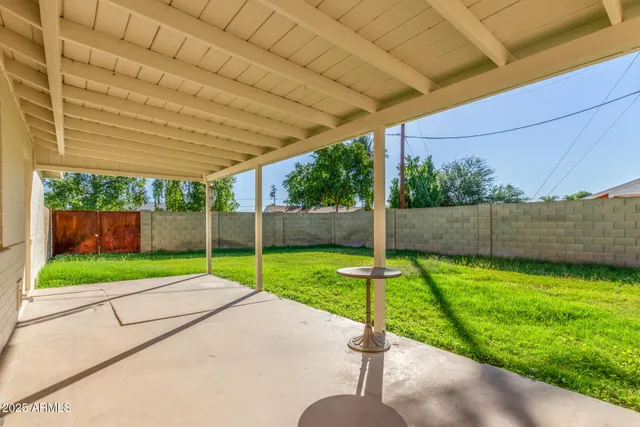 a green field with small trees in front of it
