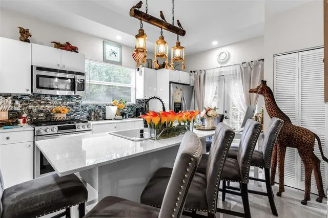 a kitchen with a table chairs sink and microwave