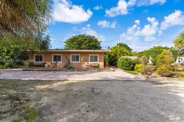 a view of a house with backyard and trees