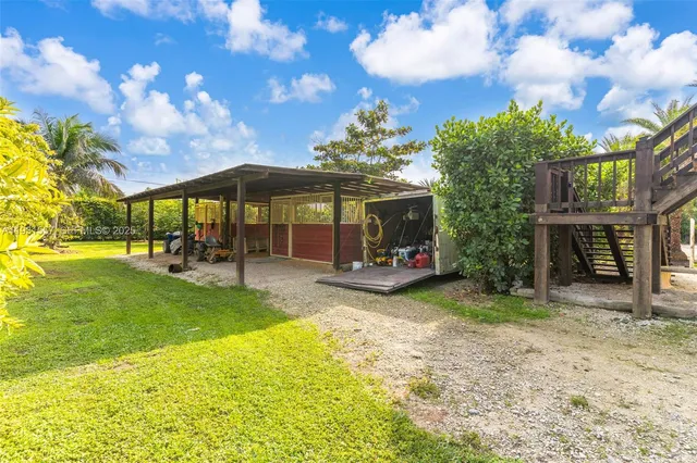 a view of a swimming pool with a table and chairs under an umbrella