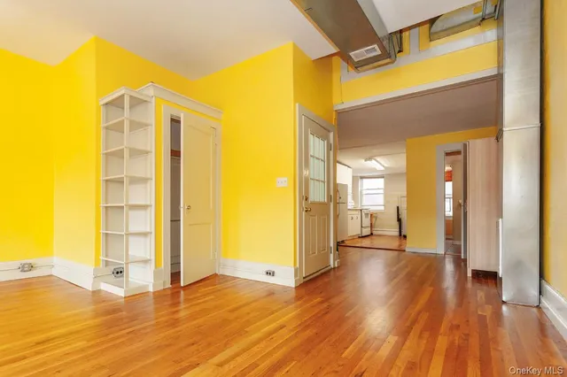 a view of a walk in closet with wooden floor