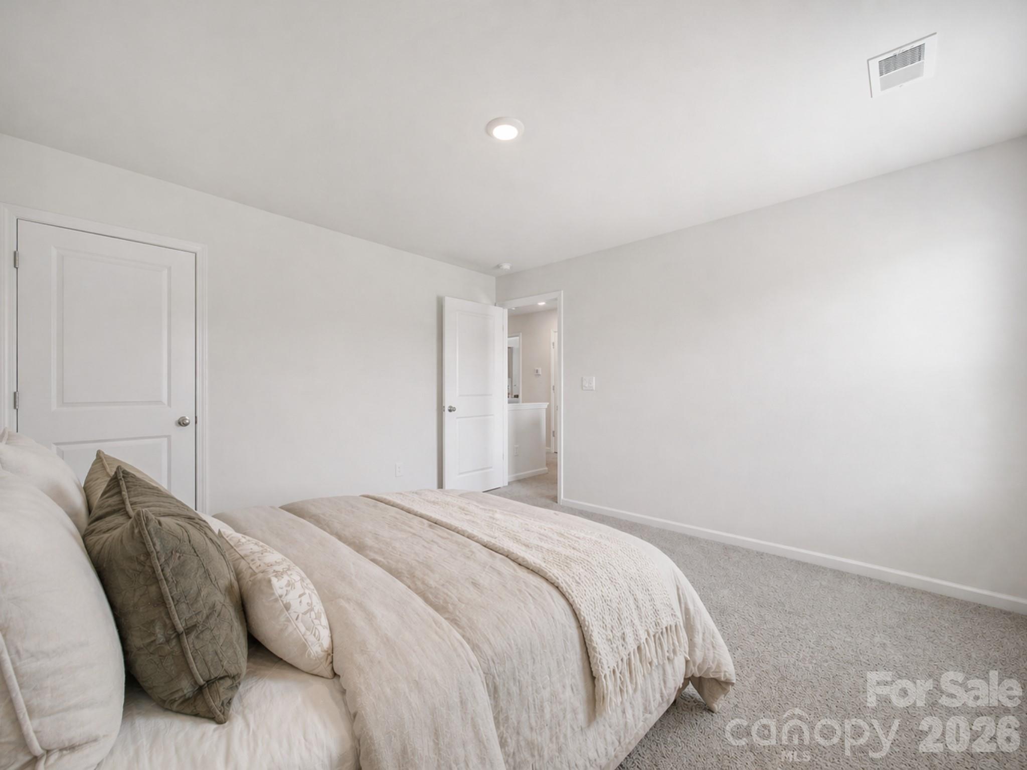 107 Spring Hall Court Troutman, NC 28166 - Photo 18 of 28 a bedroom with a bed and a night stand