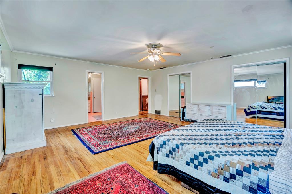 5108 Crown Road Fort Worth, TX 76114 - Photo 14 of 22 Expansive room featuring wood-finish flooring, a ceiling fan with light fixture, and two sets of mirrored closet doors