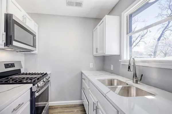 a kitchen with stainless steel appliances granite countertop a sink stove and microwave