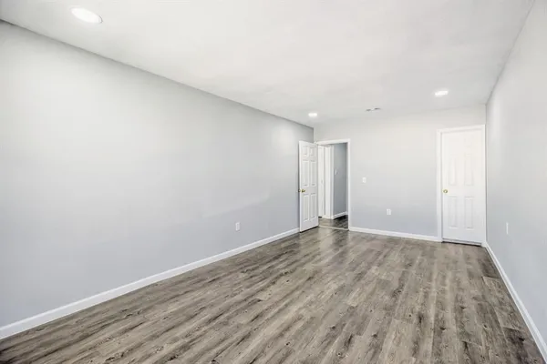 a view of an empty room with wooden floor