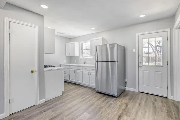 a kitchen with a refrigerator a sink and cabinets