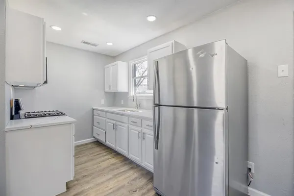 a kitchen with stainless steel appliances granite countertop a refrigerator a stove and a sink