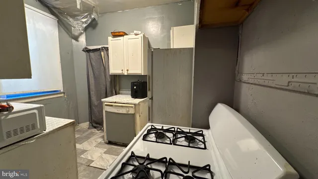 a kitchen with a refrigerator and a stove top oven