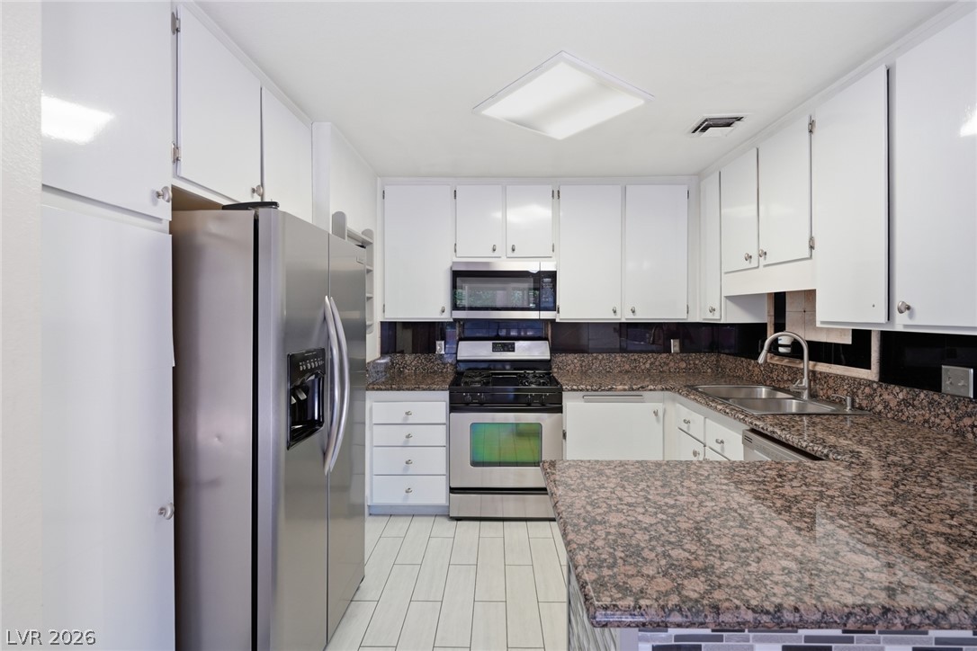 3971 Spring Leaf Drive Las Vegas, NV 89147 - Photo 28 of 48 A well-equipped kitchen features granite countertops, sleek stainless steel appliances, and ample white cabinetry.