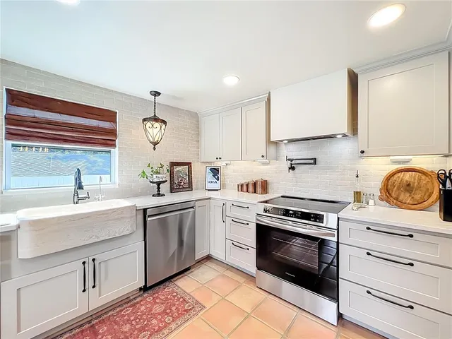 a kitchen with stainless steel appliances granite countertop a refrigerator and a stove top oven