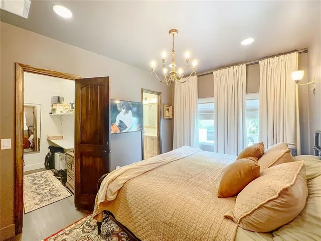 a bedroom with a large bed and a chandelier