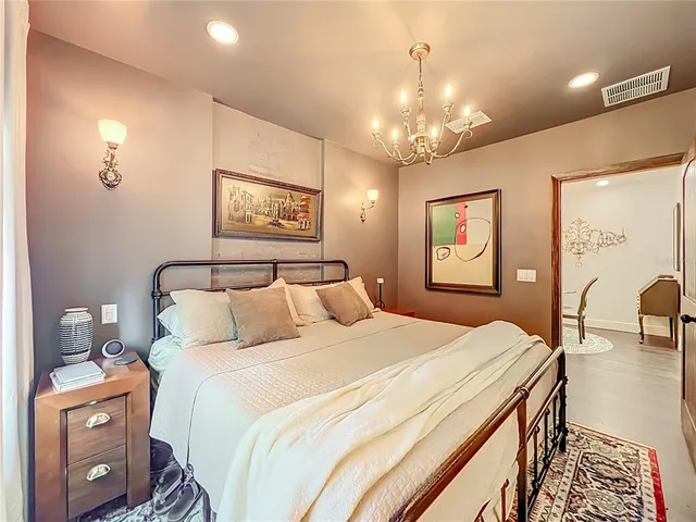 a bedroom with a large bed and a chandelier