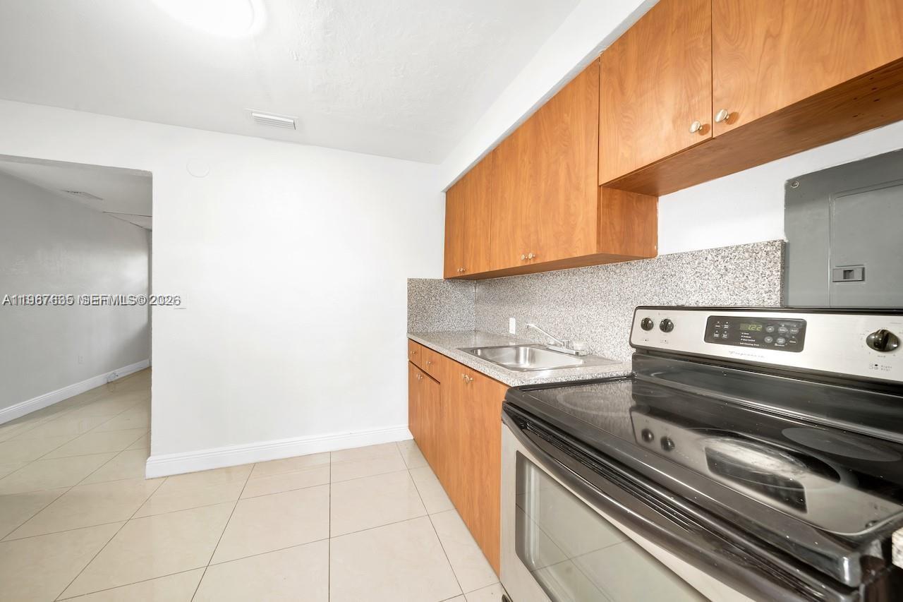 5545 Northwest 3rd Avenue, Unit W Miami, FL 33127 - Photo 3 of 8 a kitchen with a stove and a microwave