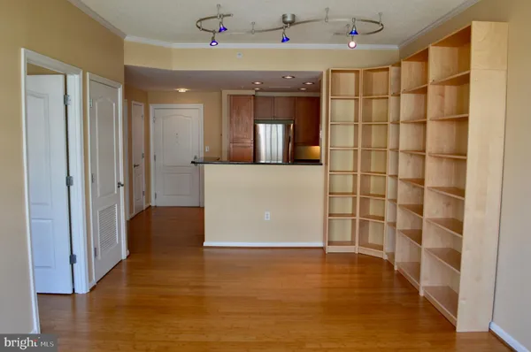 a view of a hallway with wooden floor and a cabinet