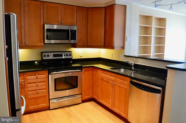 a kitchen with granite countertop stainless steel appliances a stove sink and microwave
