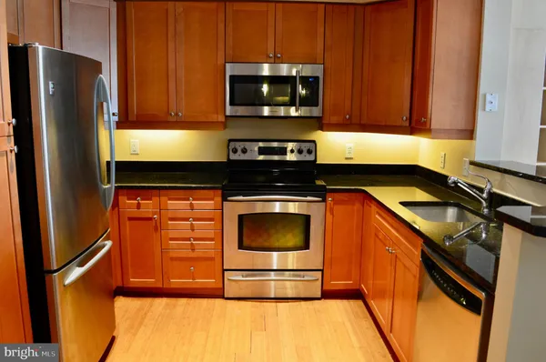 a kitchen with stainless steel appliances granite countertop a stove a microwave and a refrigerator