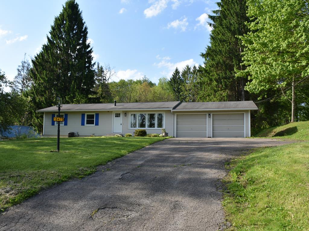 16475 Harmonsburg Road Meadville, PA 16335 - Photo 1 of 35 a front view of a house with a garden and trees