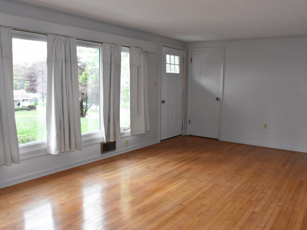16475 Harmonsburg Road Meadville, PA 16335 - Photo 6 of 35 a view of an empty room with wooden floor and a window