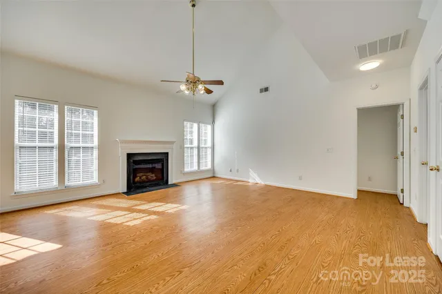 a view of an empty room with a fireplace and a window