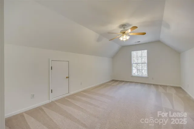a view of an empty room with a ceiling fan and window