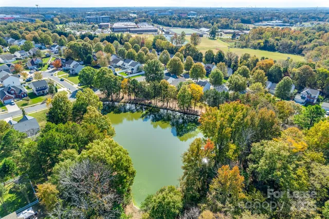 an aerial view of residential houses with outdoor space and trees all around