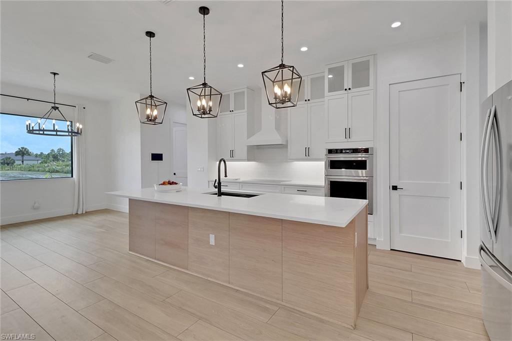 3748 Everglades Boulevard North Naples, FL 34120 - Photo 12 of 49 a large kitchen with stainless steel appliances a large counter top oven and cabinets