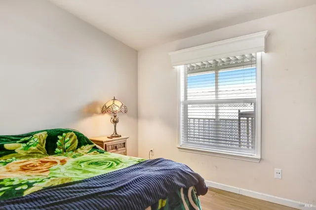a bedroom with a bed table and a window