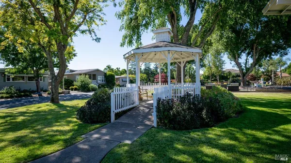 a view of a backyard with table and chairs under an umbrella