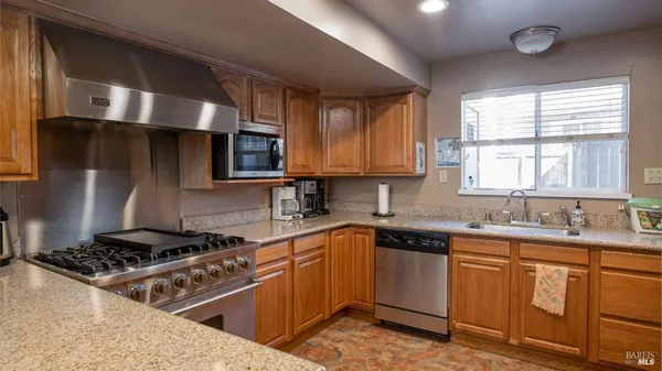 a kitchen with stainless steel appliances a sink stove and window