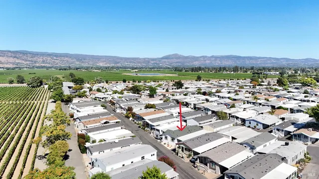an aerial view of a city with lots of residential buildings ocean and mountain view in back