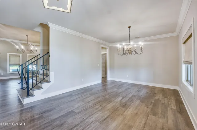 a view of a livingroom with wooden floor and stairs