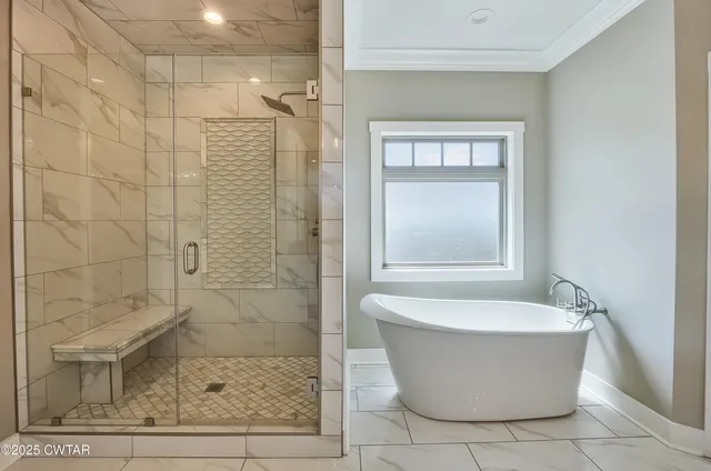 a white bath tub sitting in a bathroom next to a window