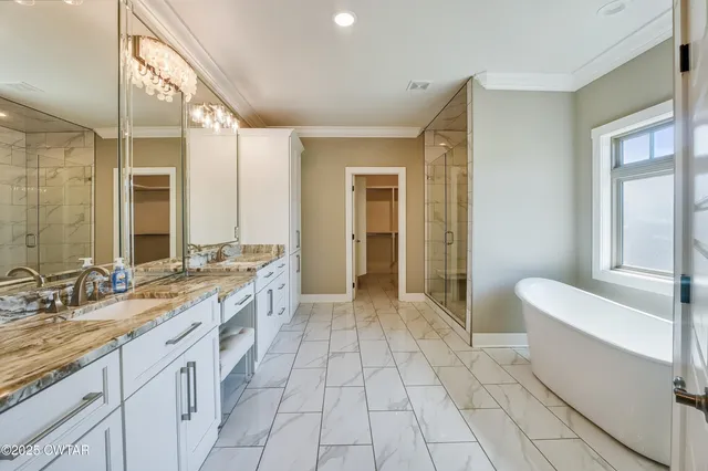 a spacious bathroom with a granite countertop sink a toilet a mirror and a bathtub